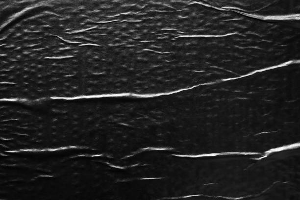 istock Black crumpled and creased paper poster texture background 1425367367