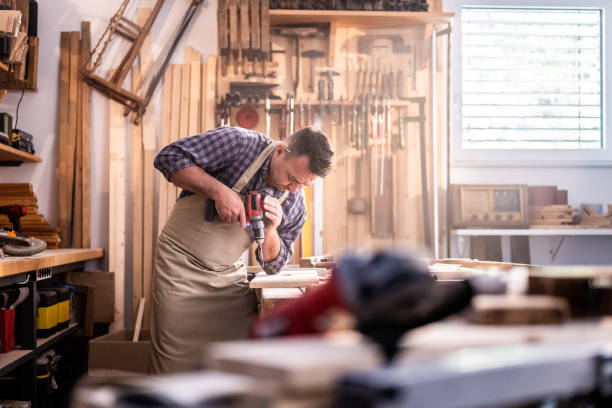 istock Man making hole in wooden part by accu drill 1425367480
