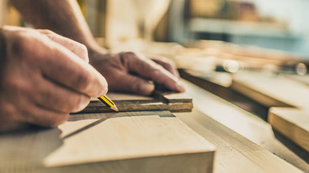 istock Male hands drawing dimensions to wooden plank 1425367540