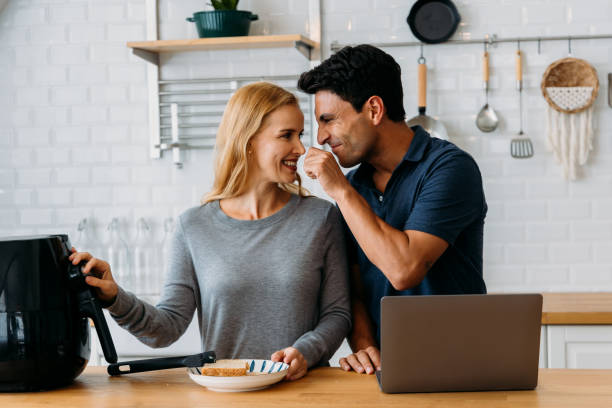 istock Woman working with airfryer and man using laptop 1425368594
