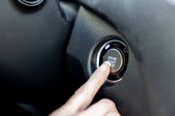 Woman Finger Pressing the Engine Start Stop Button of a Car.