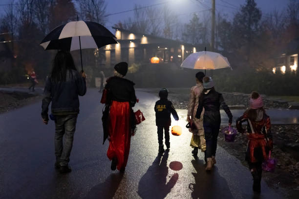 Group of People walking on illuminated street on Halloween night stock photo