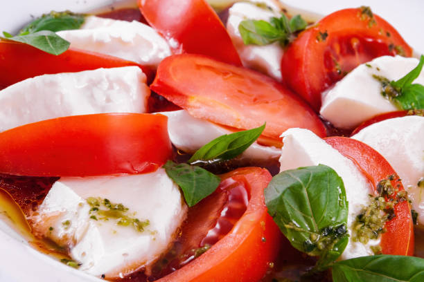 istock Caprese salad with pesto sauce on a white plate 1425378289