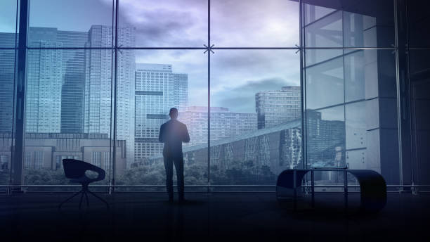 In a spacious office, a man stands and looks at city buildings, 3D render. stock photo