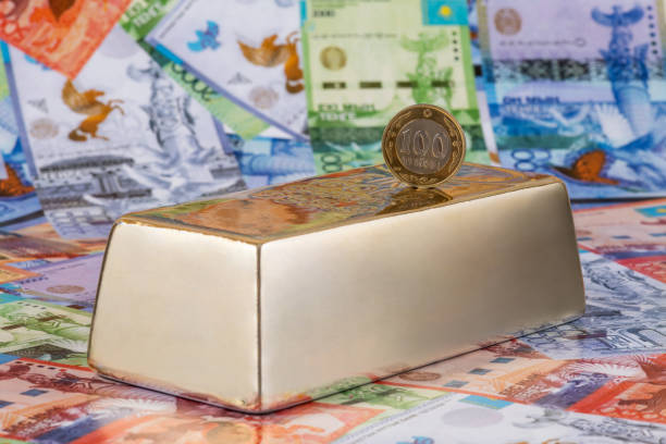kazachska moneta o wartości 100 tenge i złota sztabka na tle banknotów - borrowing bullion coin wealth zdjęcia i obrazy z banku zdjęć