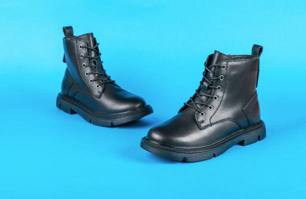 istock A pair of high leather boots on a bright blue background. 1425388703