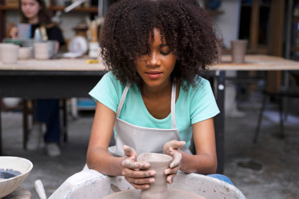 Young woman is making pottery as leisure activity. stock photo