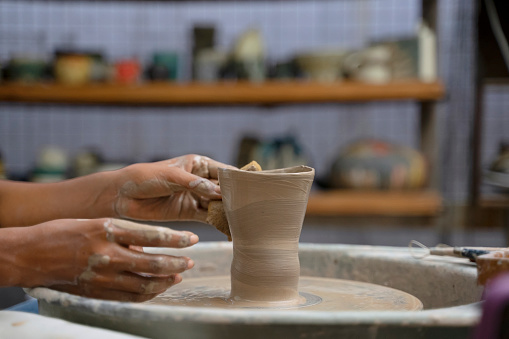 Young woman is making pottery as leisure activity. Earthenware, art and craft concept.