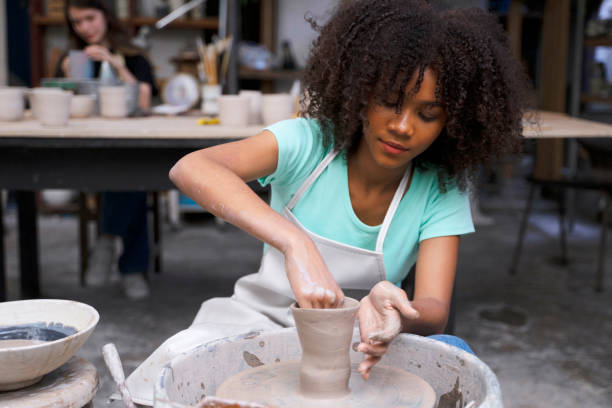 Young woman is making pottery as leisure activity. stock photo
