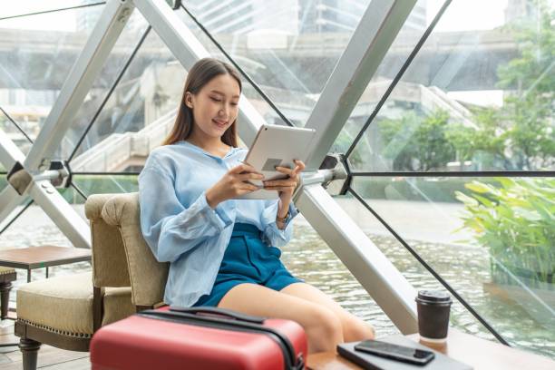 istock Beautiful young asian female solo lady traveller watching content on her digital tablet while waiting for departure in a cafe in airport terminal 1425404240