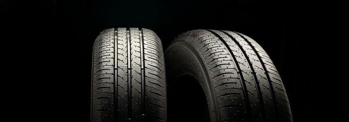 Two new summer wheels on a black tire background graphically panoramic photo.