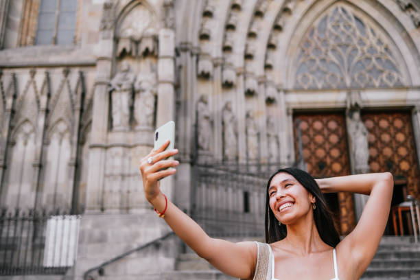 istock Happy Hispanic traveler taking selfie against old cathedral 1425412780