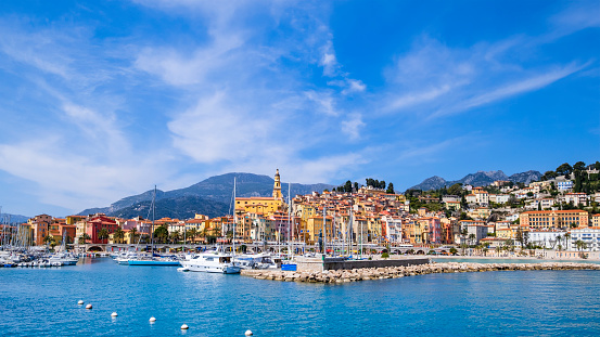 Yachts moored at the Vieux Port - Old Harbor of Menton, bordered by the characteristic colorful buildings