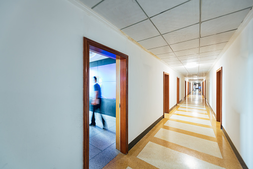Illuminated long corridor in modern office building