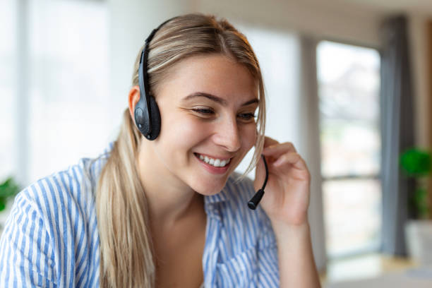 istock Business woman with headsets working with computer at office. Customer service assistant working in office.woman operator working with headsets and laptop at telemarketing customer service. 1425424008