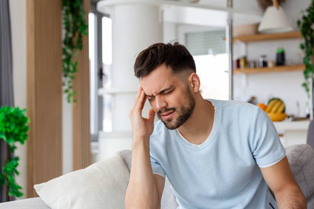 istock Upset man squeezing head with hands, writhing in pain, suffering from headache at home, copy space 1425424996