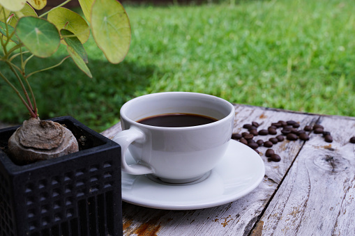Hot americano coffee on an old wooden table.. a cup of coffee on a plate.  Americano black coffee.  coffee cup on wooden floor  Afternoon is the best time to drink coffee.