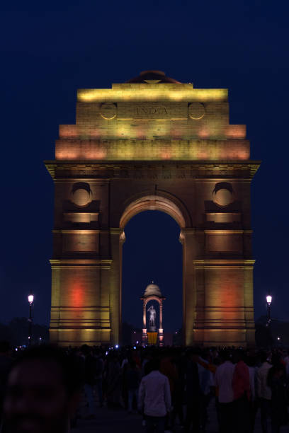 nova deli, índia, 17 set 2022: multicolor iluminada india gate multidão de turistas à noite, parte do trecho redesenvolvido central vista em delhi - new delhi india night government - fotografias e filmes do acervo