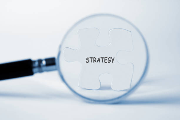 istock Strategy word with hand holding magnifying glass over jigsaw puzzle 1425441290