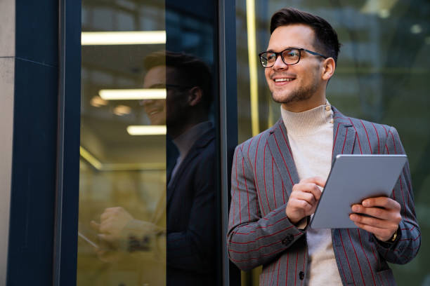 istock Successful happy business man working on digital tablet in urban background 1425445646