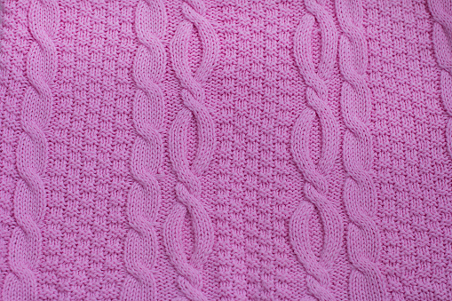 patterned knitted fabric in the Irish style. The texture of knitted fabric knitted with knitting needles