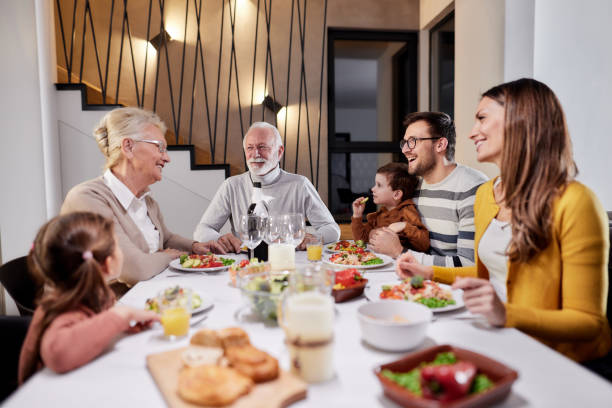 Happy extended family talking during lunch in dining room.