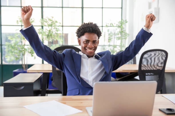 istock Portrait of young content office worker raising hands, smiling 1425453629