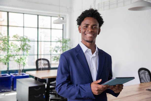 istock African-American office worker holding tablet, looking at camera 1425453650