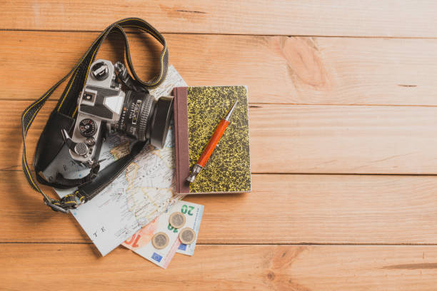 istock Camera, map, notebook, ball pen and money on wooden table 1425456999