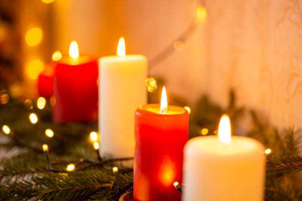 istock Line of burning red and white candles on fir tree branches 1425462491