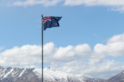 The flag of New Zealand flies in the wind at Tekapo Airport.  This image was taken on an afternoon in early Spring.