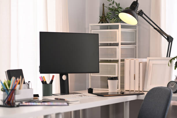 istock A blank computer screen, stationery and lamp on white table in modern home office interior. 1425463184