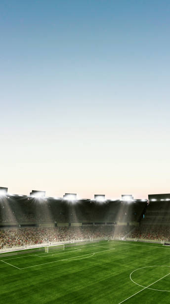 istock Empty large football field with flashlights and sunny cloudy sky background. Stadium with filled stands with sports soccer fans. 1425463195