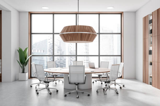 Light office room interior with seats, table and shelf near panoramic window