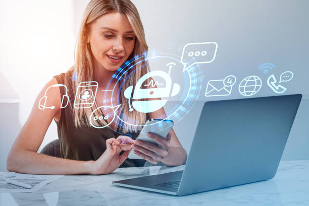 istock Businesswoman with phone, computer and digital bot hologram 1425463884