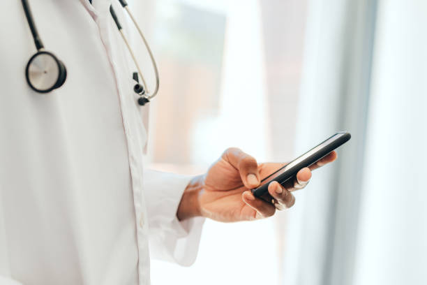 Hand of black healthcare doctor with phone, 5g mobile device or smartphone for calling or communication. African man or person on digital cellphone technology app reading online medical internet news stock photo