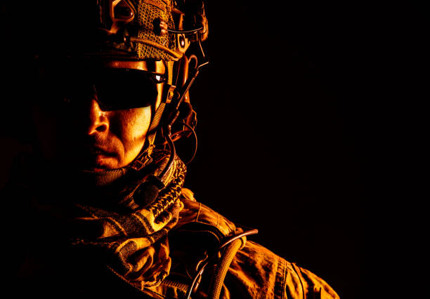 Elite member of US Army ranger in combat helmet and dark glasses. Studio shot, dark black background, looking at camera, dark contrast, toned and colorized stock photo