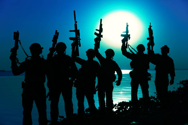 istock Army soldiers with rifles moon night silhouette 1425466477