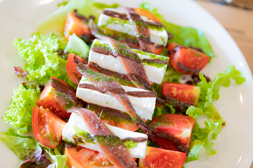 Anchovies salad with goat cheese, cherry tomatoes and letutce