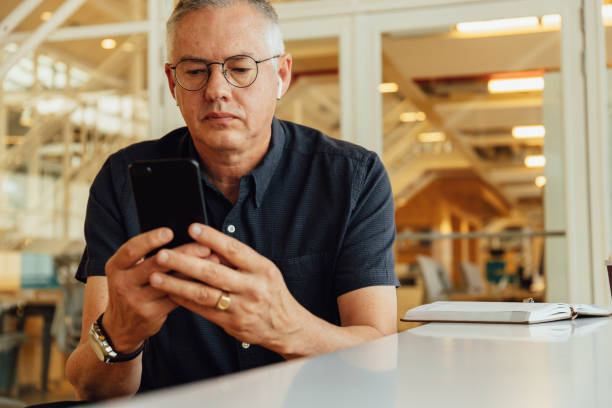 istock Businessman with diary on desk using smartphone in office 1425468454