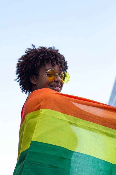 istock Young man with afro hair in the city with the pride flag 1425469607