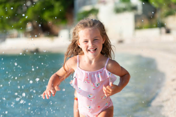 The child runs along the beach on sea water.