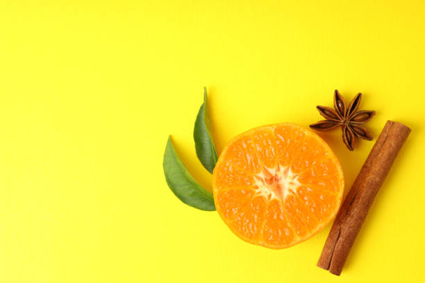 istock Mandarin with leaves and cinnamon on yellow background 1425472553