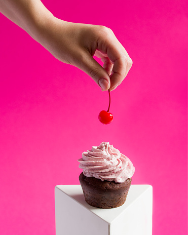Cherry cupcake on a pink background