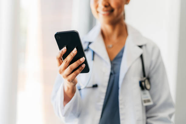 Phone, hand and medicine with a doctor doing research online with mobile technology. Communication and networking with a woman surgeon working in a hospital for healthcare, science and medical care stock photo