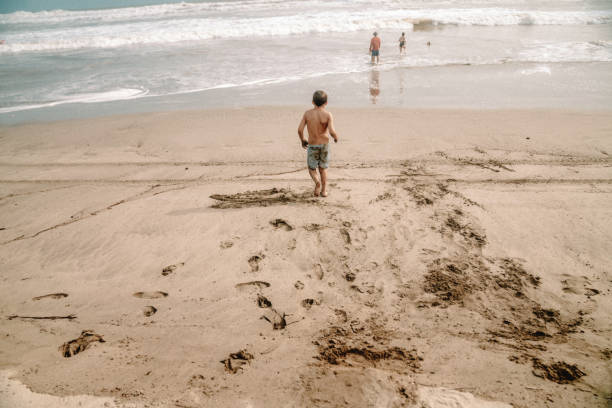 istock Kids playing at the beach 1425474471