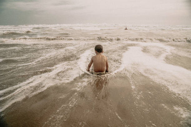istock Kids playing at the beach 1425474664