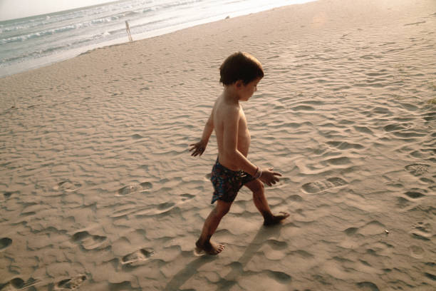 istock Kids playing at the beach 1425474761