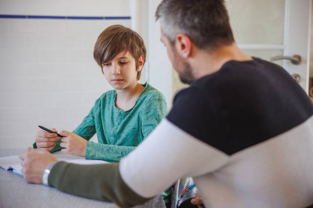 istock Preadolescent boy sitting at home and talking to his tutor 1425475166