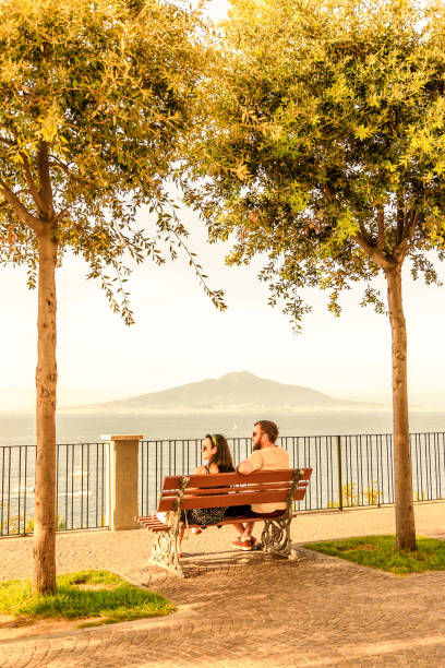 casal sentado em um banco em frente ao vesúvio - bench mountain park sitting - fotografias e filmes do acervo